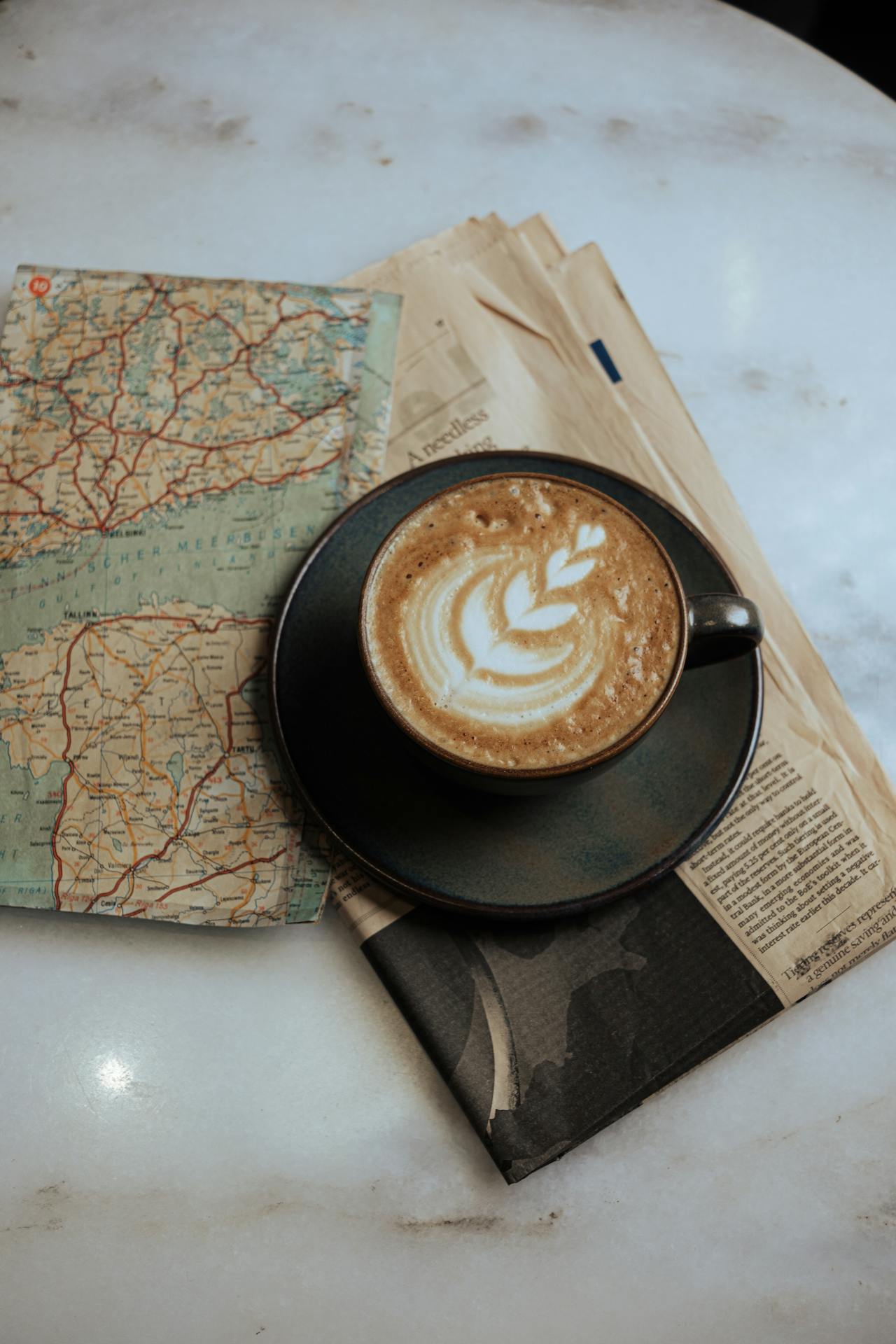 A map with coffee cup. Photo by Zişan  Özdemir: https://www.pexels.com/photo/a-cup-of-coffee-sits-on-top-of-a-newspaper-28285710/